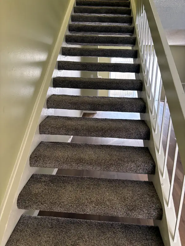 Greige carpet on an open-rail staircase
