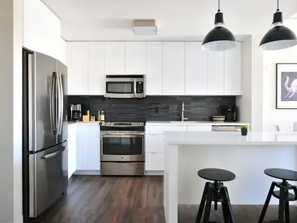 Modern white kitchen with black stools